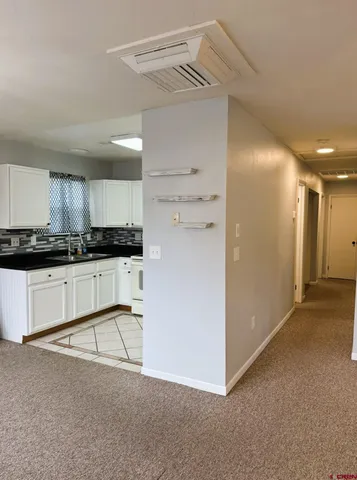 a view of kitchen with granite countertop cabinets and refrigerator