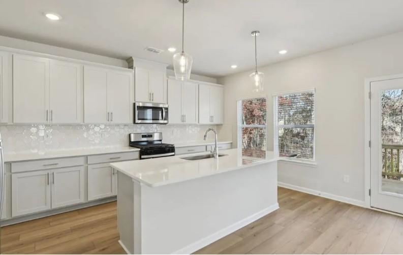 7231 Lyric Street Fairburn, GA 30213 - Photo 5 of 12 a kitchen with stainless steel appliances granite countertop a sink a stove and a refrigerator