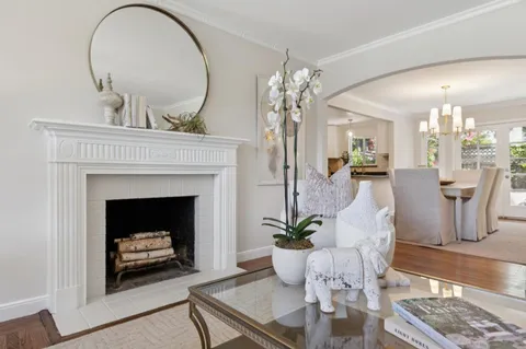 a living room with furniture a chandelier and a fireplace