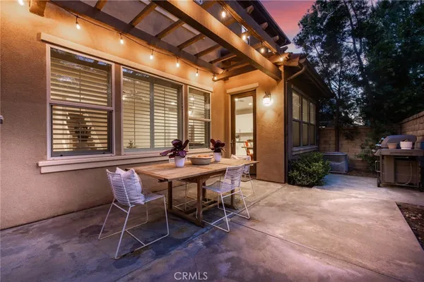 a view of a house with a chairs and table in the patio
