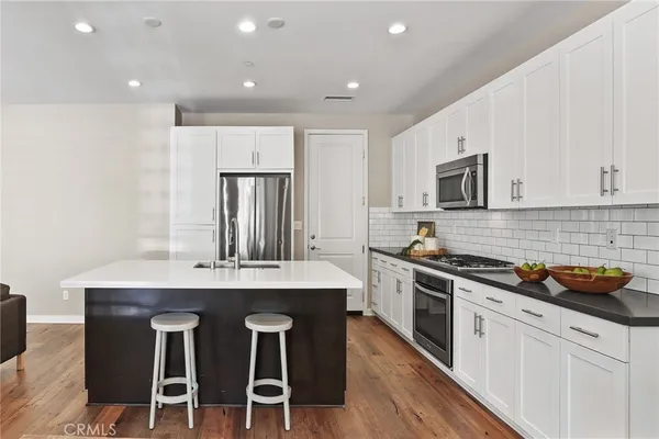 a kitchen with cabinets a sink and stainless steel appliances