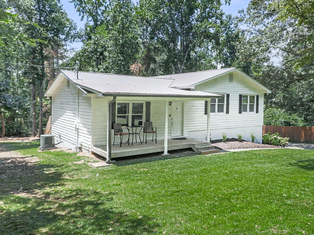 a view of a house with a yard and sitting area