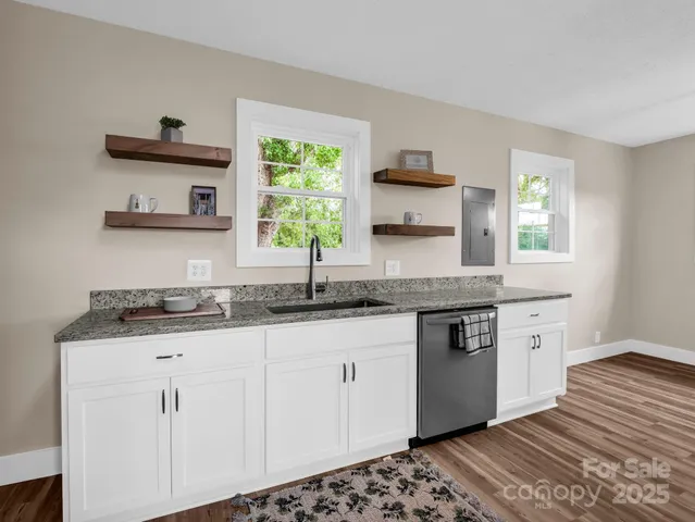 a kitchen with granite countertop a sink cabinets and window