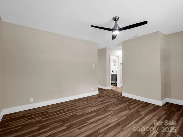 a view of a room with wooden floor and white walls