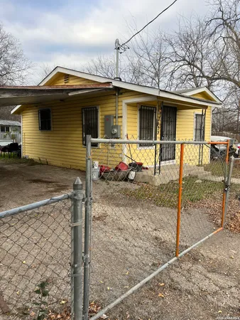 a view of a house with wooden fence