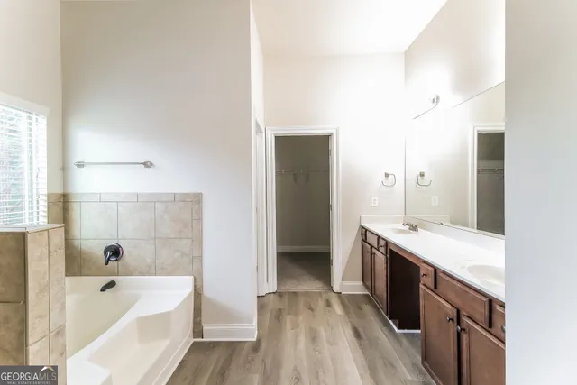 a bathroom with a tub sink and mirror