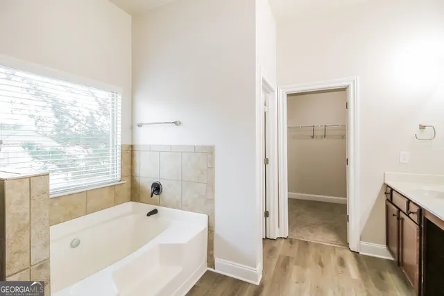 a bathroom with a tub a sink and a shower