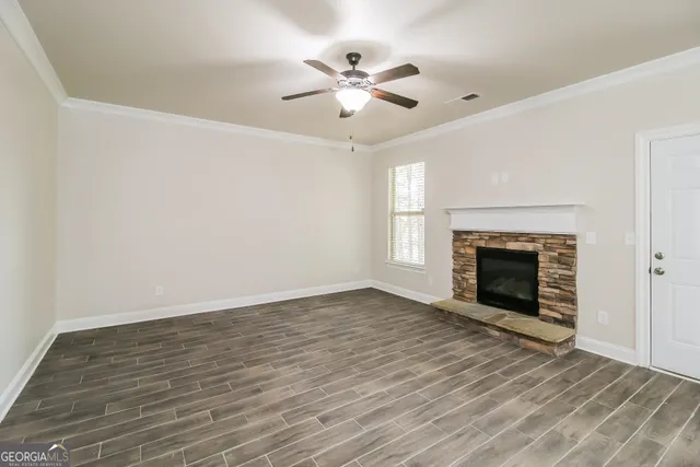 an empty room with fan and fireplace