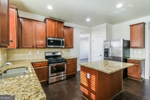 a kitchen with stainless steel appliances granite countertop a stove refrigerator and microwave