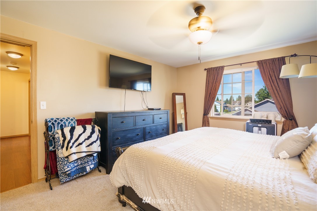 417 Spring Lane Sedro-Woolley, WA 98284 - Photo 14 of 29 a bedroom with a bed and a chandelier