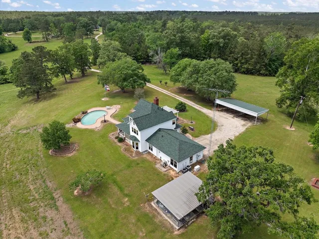 an aerial view of a house with a yard basket ball court and outdoor seating