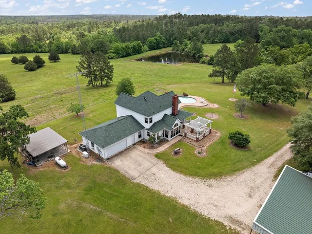 an aerial view of a house with outdoor space swimming pool and mountains