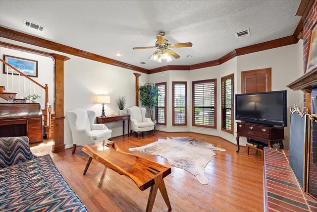 a living room with furniture a flat screen tv and wooden floor