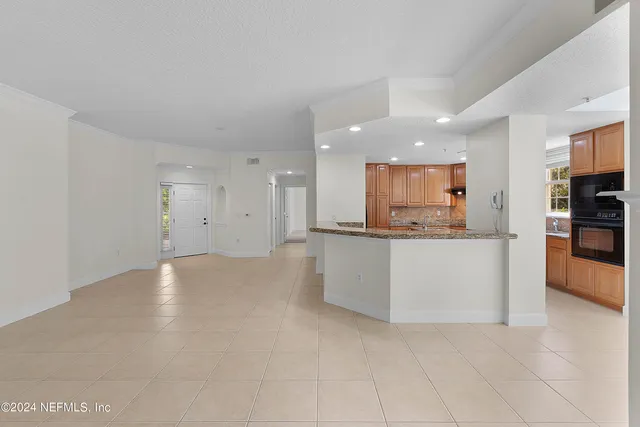 a view of kitchen with kitchen island and stainless steel appliances