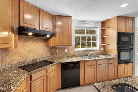 a kitchen with stainless steel appliances granite countertop a sink stove and cabinets