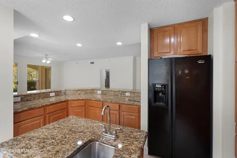 a kitchen with stainless steel appliances granite countertop a refrigerator and a sink