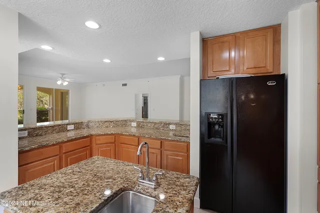 a kitchen with stainless steel appliances granite countertop a refrigerator and a sink
