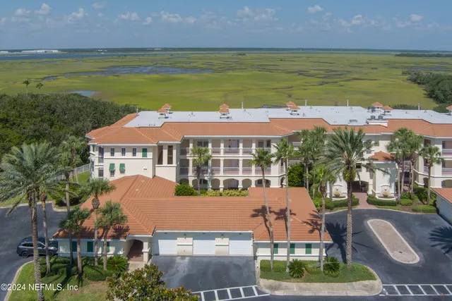 an aerial view of residential houses with outdoor space and ocean view