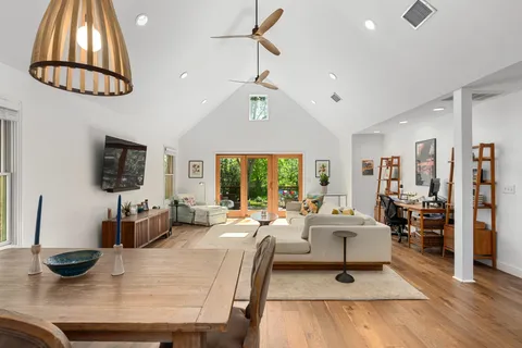 a living room with furniture a flat screen tv and a large window