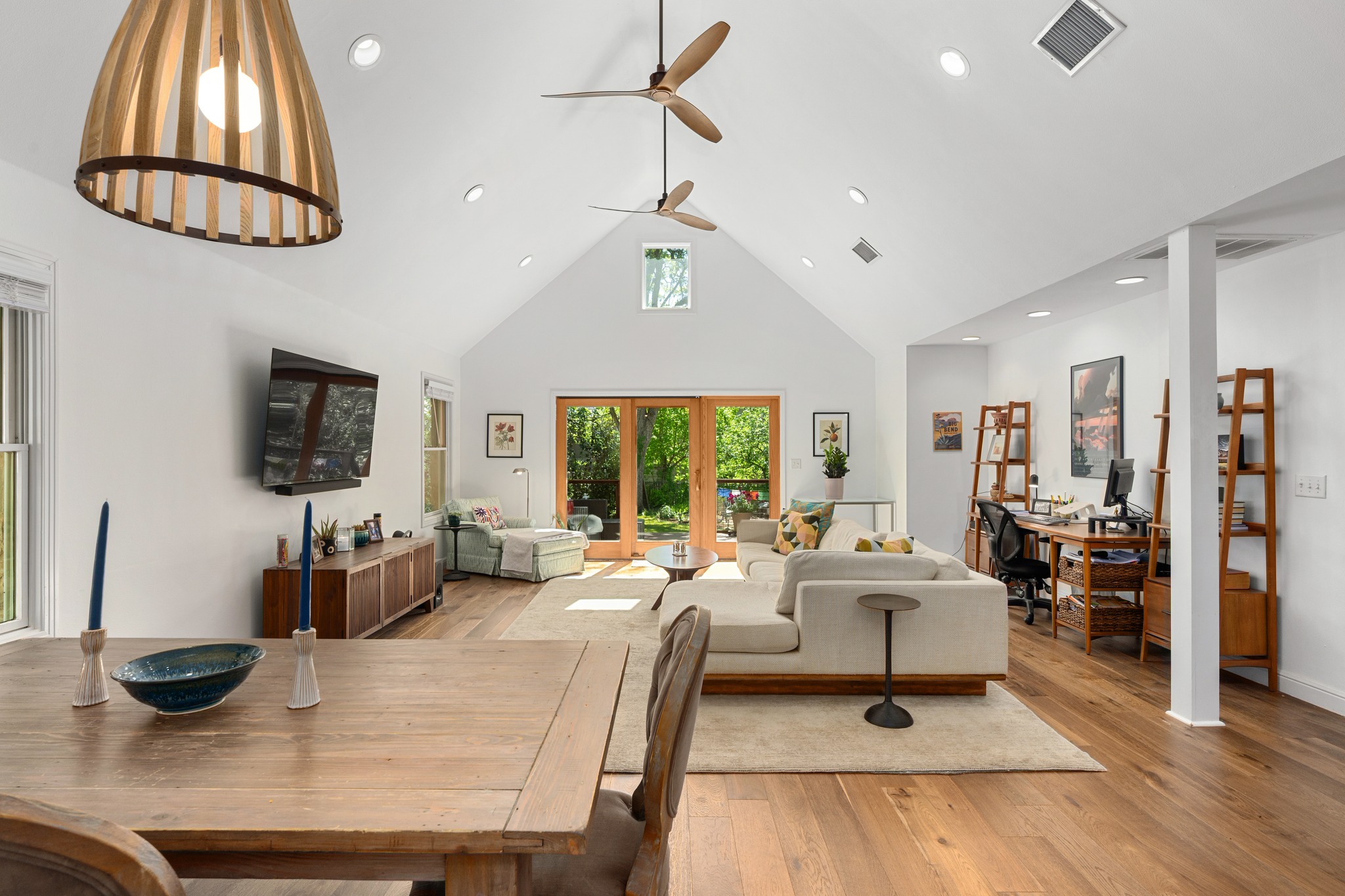 Dining area featuring a high ceiling, light wood finished floors, french doors, an office area, and a ceiling fan