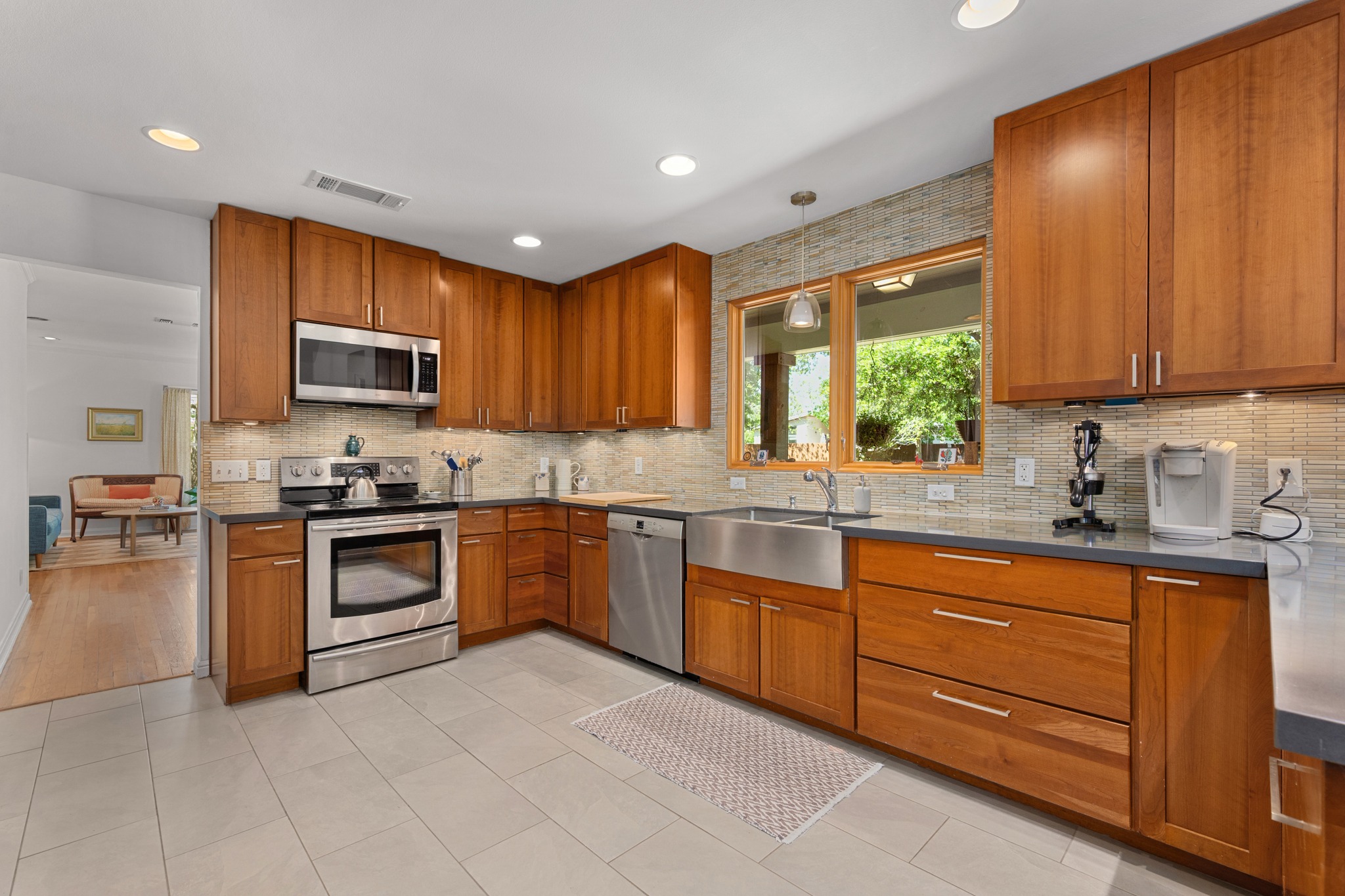 6103 Bull Creek Road Austin, TX 78757 - Photo 10 of 29 Kitchen featuring wood finish cabinets, stainless steel appliances, light tile patterned floors, and hanging light fixtures