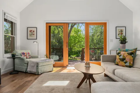 a living room with furniture kitchen view and a wooden floor