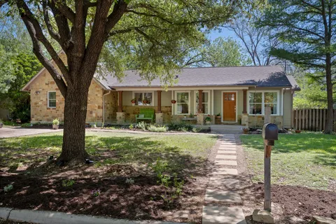 a front view of a house with yard and green space