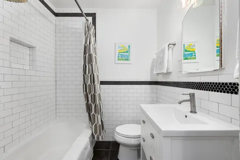 a bedroom with a bed a dresser and a large window