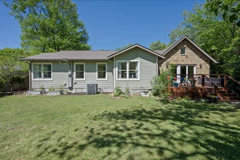 a view of a house with a yard and sitting area