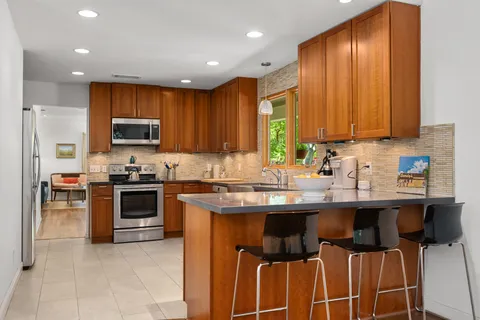 a kitchen with stainless steel appliances granite countertop a stove sink and cabinets