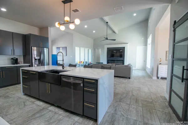 a kitchen with a chandelier stainless steel appliances a sink cabinets and a counter top space