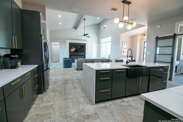 a kitchen with kitchen island granite countertop a sink counter top space appliances and cabinets