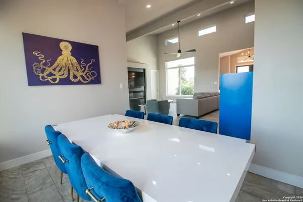 a living room with stainless steel appliances furniture a dining table and window