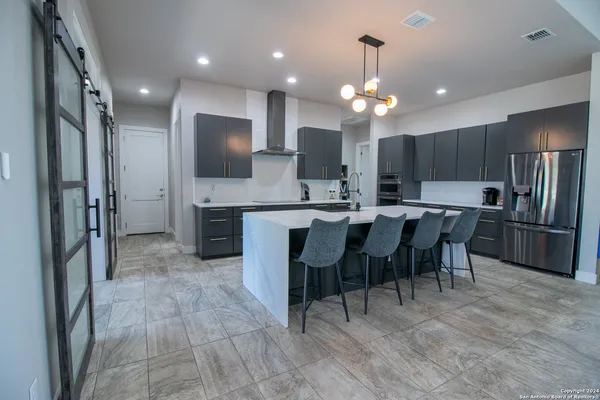a kitchen with refrigerator a sink and chairs