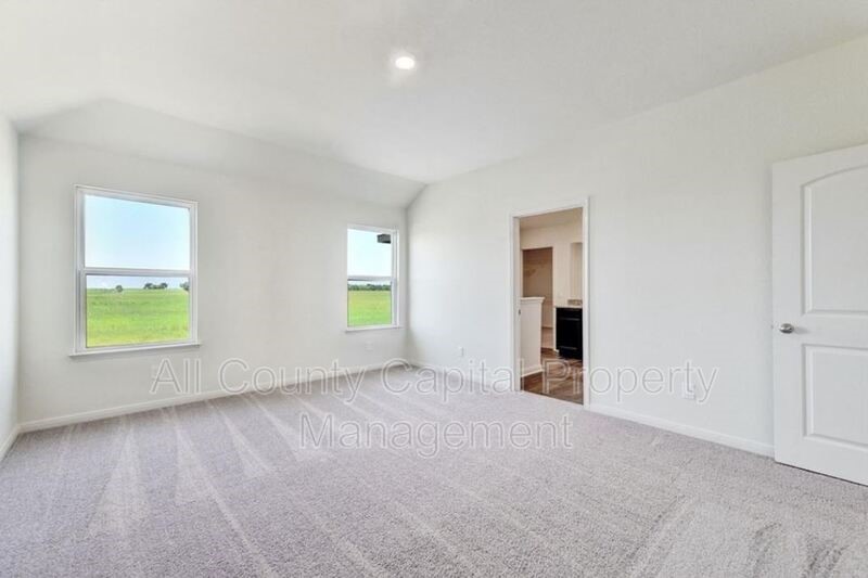 18640 Quiet Range Drive Elgin, TX 78621 - Photo 3 of 9 a view of an empty room with a window and a kitchen