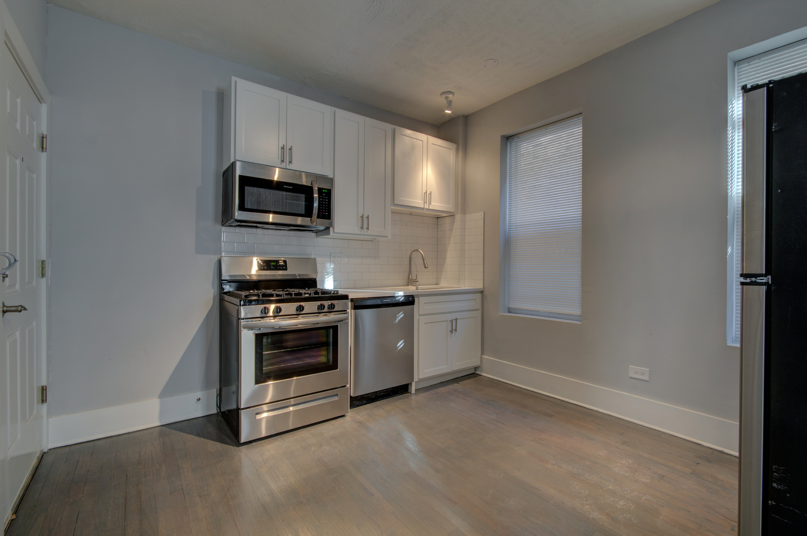 1706 South Carpenter Street, Unit 1R Chicago, IL 60608 - Photo 2 of 8 a kitchen with stainless steel appliances a stove a microwave and a refrigerator