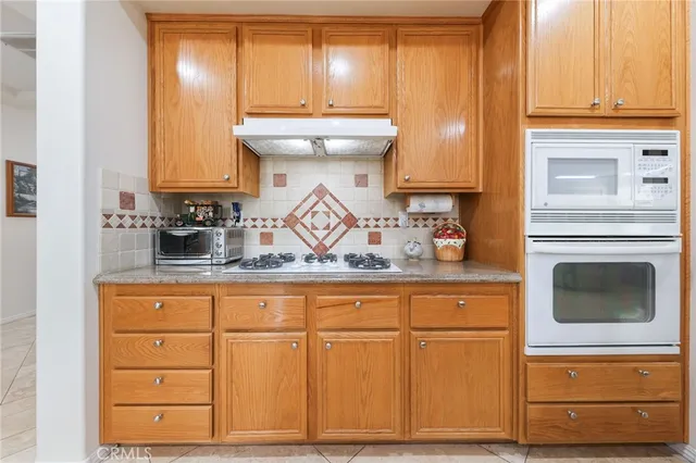 a kitchen with stainless steel appliances granite countertop a sink and a refrigerator