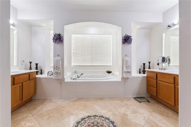 a spacious bathroom with a tub sink and mirror