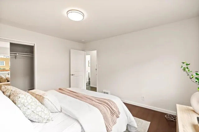 a bedroom with a bed and a potted plant