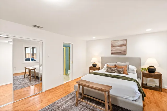 a bedroom with a bed and wooden floor