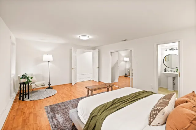 a bedroom with a bed and closet with mirror