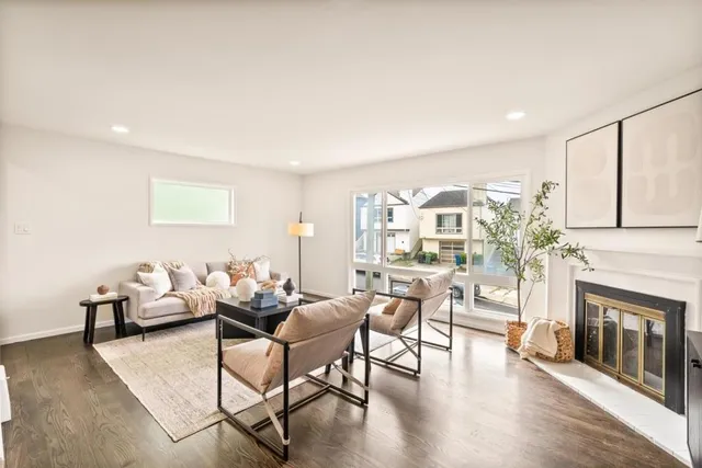 a living room with furniture a fireplace and a large window