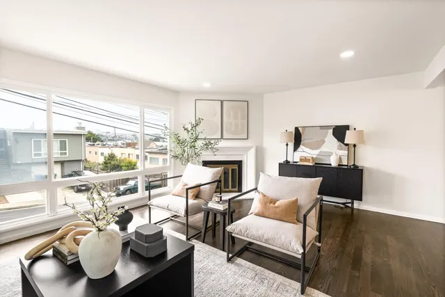 a living room with furniture fireplace and a large window