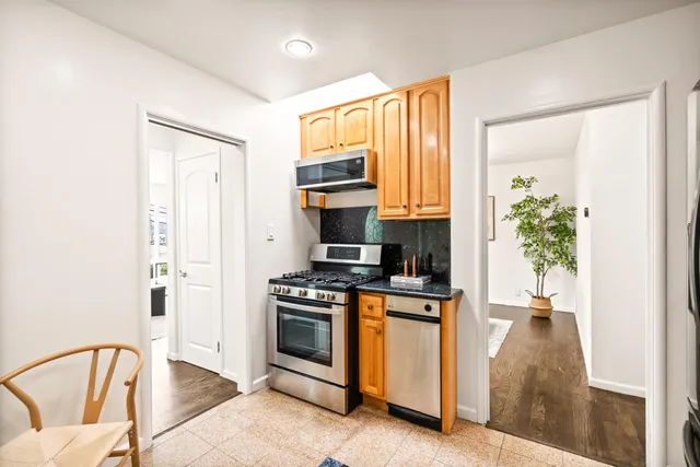 a kitchen with stainless steel appliances granite countertop a stove a sink and a microwave