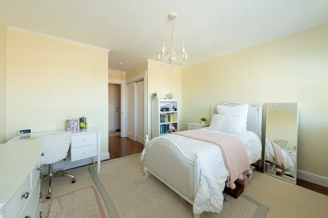 a spacious bedroom with a bed and a chandelier
