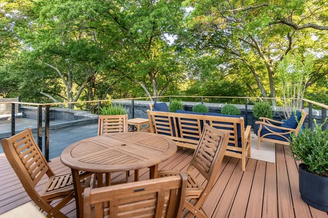 a balcony with wooden floor table and chairs