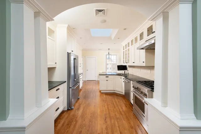a large white kitchen with stainless steel appliances