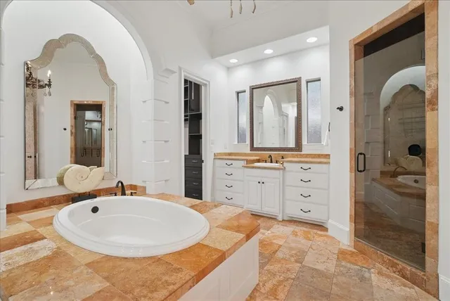 a bathroom with a tub sink and mirror