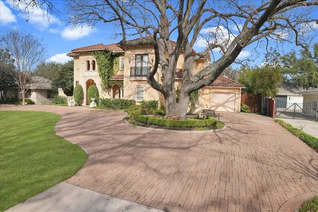 a front view of a house with a yard and trees