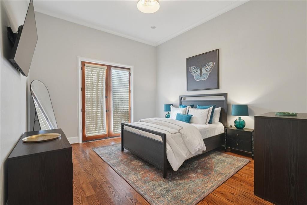 6807 Lupton Drive Dallas, TX 75225 - Photo 23 of 40 a bedroom with a bed and a flat tv screen on a dresser